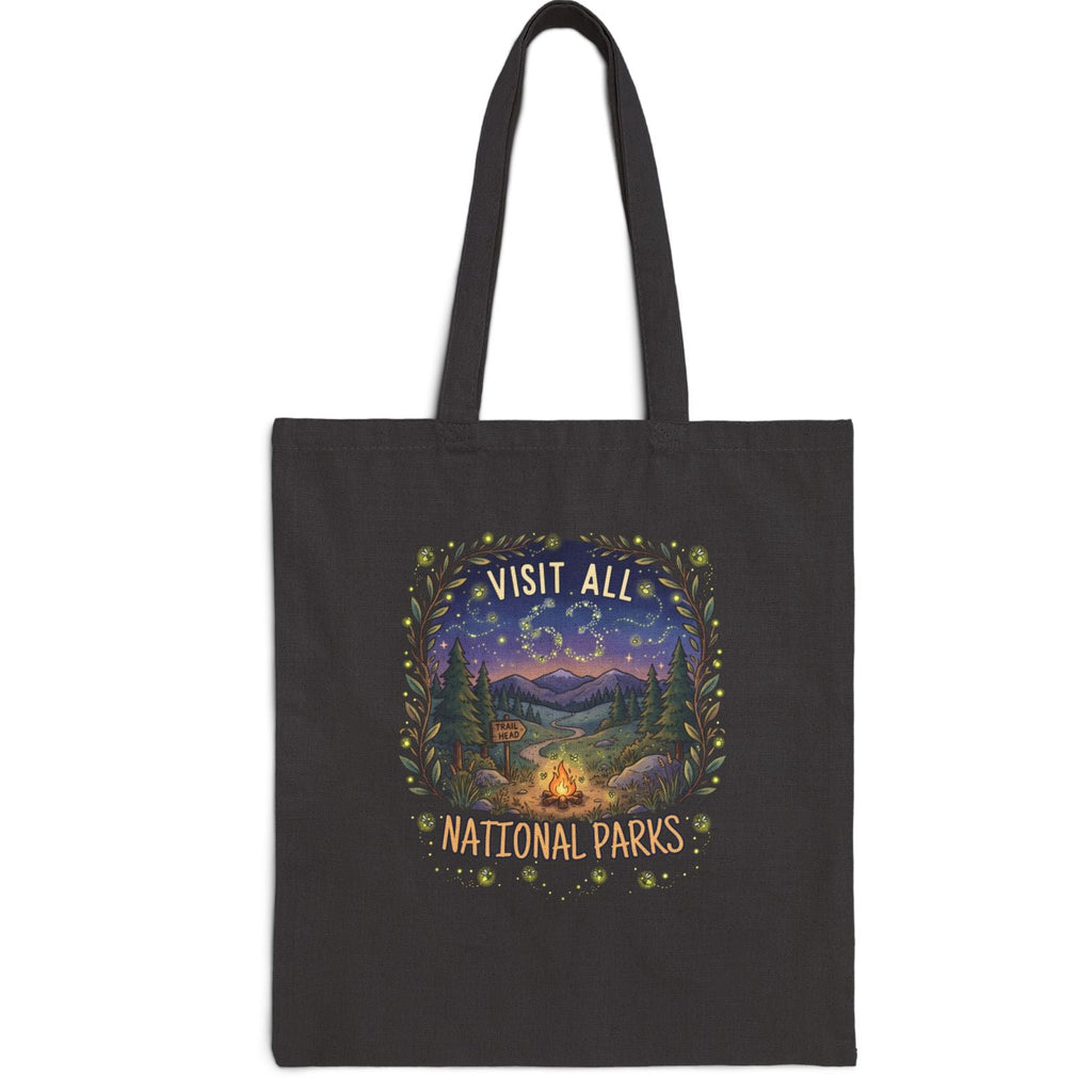 A black canvas tote bag with two shoulder straps, featuring a central graphic print that reads 'VISIT ALL 63 NATIONAL PARKS' in a scenic mountain landscape with a campfire and stars.