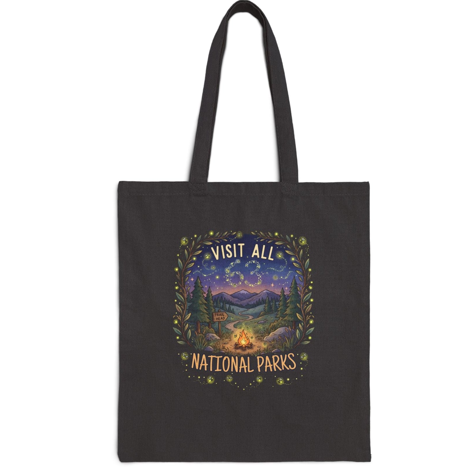 A black canvas tote bag with two shoulder straps, featuring a central graphic print that reads 'VISIT ALL 63 NATIONAL PARKS' in a scenic mountain landscape with a campfire and stars.